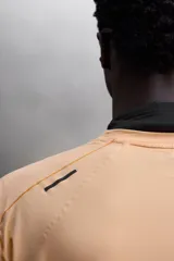 Camiseta deportiva color naranja confeccionada en tejido técnico, ligero y elástico. Tiene cuello redondo, mangas cortas y logo estampado.