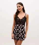 Camisón corto de microfibra con estampado floral, presenta un diseño con escote en V decorado con encaje negro y breteles finos ajustables.