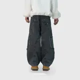 Pantalón de jean estilo ultra baggy, color negro con efecto lavado. Presenta un diseño de corte amplio con costuras reforzadas y detalles de bordes desflecados en los bolsillos laterales tipo cargo.