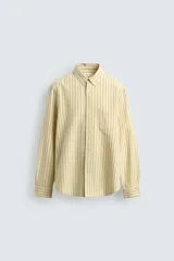 Camisa de corte regular fit de tejido de algodón, con diseño de rayas verticales amarillas y azules. Cuenta con cuello abotonado, manga larga con puños abotonados, un bolsillo aplicado en el pecho y cierre frontal con botones.