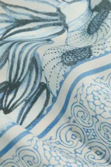 Pañuelo cuadrado de diseño estampado con motivos marinos en tonos azules y fondo claro, con bordes decorativos.