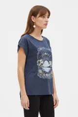 Remera azul marino de manga corta holgada con cuello redondo y estampa frontal de paisaje marino con fases lunares y flores.