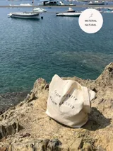 Tote bag color crudo con estampa negra con la frase "Slow Outfit" repetida.