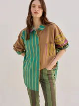 Camisa de algodón liviano con diseño de rayas multicolor, corte holgado, cuello camisero, mangas largas y bolsillo frontal.