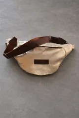 Riñonera con estampado animal, con detalles en cuero color chocolate y correa regulable.