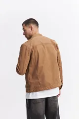 Campera de efecto gamuza con cierre frontal, cuello mao y bolsillos laterales con cierre. Presenta un diseño de corte regular con textura suave.