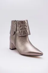 Botas cortas de cuero negro con taco cuadrado y punta fina. Presentan cuello caído capitoneado con apliques brillantes y cierre lateral con cremallera.