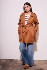 Trench marrón de gamuza vegana con cuello solapa, manga larga, cinturón con hebilla y corte evasé.