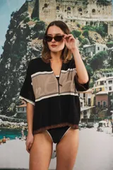 Remera de punto con diseño retro de bloques de color en marrón, crema y celeste. Presenta cierre frontal, cuello redondo, mangas cortas y tejido calado en la parte inferior. Incluye detalle de logo en relieve en el frente.