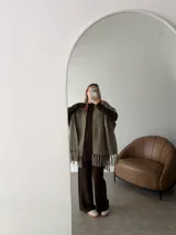 Ruana negra de tejido liviano con terminación de flecos en el ruedo y mangas amplias.