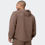 Canguro negro de tejido ComfortKnit con textura tipo waffle, capucha estructurada, media cremallera frontal y bolsillo tipo canguro con compartimento integrado para el móvil.