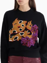 Sweater negro de tejido cálido con cuello redondo y mangas largas. Presenta un bordado frontal multicolor con motivos de fuego y flores.