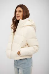 Campera puffer corta de color beige, con capucha integrada, cierre frontal y diseño acolchado.