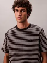 Remera de manga corta con cuello redondo, confeccionada en tejido de algodón con diseño de rayas horizontales finas. Presenta el logo de la marca bordado en el pecho.