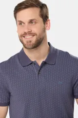 Remera polo de piqué en color azul con estampado de mini print geométrico en toda la prenda. Presenta cuello clásico, cierre frontal con botones personalizados y logo bordado en el pecho.