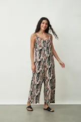 Monoprenda (jumpsuit) de mujer con estampado abstracto en tonos negro, marrón y blanco. Presenta escote en V, tirantes finos ajustables y pierna ancha tipo palazzo.