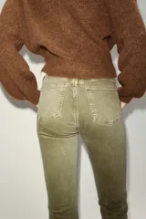 Jeans de tiro alto con diseño cropped flare, cinco bolsillos y bajo deshilachado. Cierre frontal con cremallera y botón metálico.