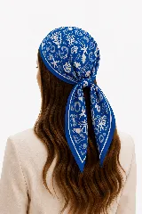 Pañuelo azul con estampado abstracto en tonos claros y borde contrastante, diseñado para usar en la cabeza o el cuello.