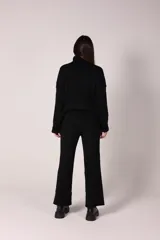 Conjunto de dos piezas compuesto por un sweater de cuello alto y pantalón de corte recto, ambos confeccionados en tejido de punto acanalado.