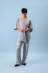 Conjunto de dos piezas (camisa y pantalón) de tejido acanalado gris, con camisa estilo kimono de manga ancha y cuello V cruzado, ajustada a la cintura con un lazo de tela.