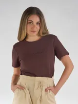 Remera blanca de manga corta, cuello redondo con detalle de costura decorativa a tono, y bordado frontal a tono.