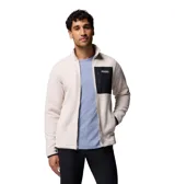 Campera de polar tipo sherpa en color beige, con cierre frontal completo y cuello alto. Presenta un bolsillo frontal en el pecho con cierre y revestimiento en contraste negro, además de bolsillos laterales. Incluye el logo de la marca en el bolsillo del pecho.