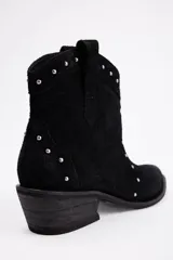 Botas texanas cortas de cuero vacuno color negro, con diseño de punta fina y taco cuadrado. Presentan detalles de tachas metálicas plateadas distribuidas en la parte frontal y lateral.