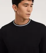 Remera de manga larga con textura vertical, cuello redondo y puños con detalle de borde contrastante en color blanco. Confeccionada en tejido de poliéster y algodón.