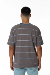 Remera gris a rayas horizontales blancas y azules, con cuello redondo azul y logo 'Vernal' bordado en azul. Corte holgado.