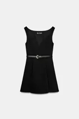 Vestido corto negro sin mangas, con escote en pico profundo y falda con pliegues. Incluye un cinturón fino de cuero sintético con hebilla metálica dorada en la cintura. Cierre lateral con cremallera oculta.