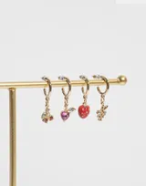 Aros tipo argolla pequeña en tono dorado con dije colgante en forma de racimo de uvas, decorado con pequeñas piedras brillantes en tonos violeta y morado.