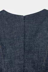 Blusa de Zara confeccionada en mezcla de algodón con acabado denim. Presenta escote redondo, mangas cortas abullonadas con volumen y costuras con pespuntes a contraste. Cierre posterior con cremallera oculta.