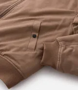Campera bomber de sarga color tostado con cuello desmontable de pelo sintético oscuro. Presenta cierre frontal de cremallera, puños y cintura acanalados, y bolsillos laterales.