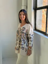 Sweater de punto con cuello en V, diseño holgado y estampado animal print con detalles en dorado.