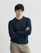 Sweater de punto con escote redondo, confeccionado en algodón con textura de punto fantasía en cuerpo y mangas, y terminaciones en punto canalé en cuello y puños.
