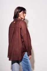 Camisa marrón de tencel y poliéster, corte oversize, manga larga y cierre con botones.