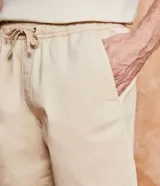 Bermuda masculina color gris claro, de sarga con efecto jaspeado, cintura elástica ajustable con cordón, bolsillos laterales y traseros, y etiqueta en la barra.