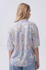 Blusa estampada con botones en el frente y mangas tres cuartos.