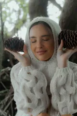 Buzo de punto calado con capucha integrada, de manga larga y diseño holgado, confeccionado en tejido de textura suave.