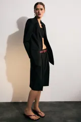 Blazer marrón de cuello solapa con muescas, manga larga y bolsillos de vivo con solapa. Cierre frontal con un botón.