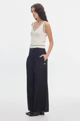 Pantalón wide leg de algodón color negro, con cintura ajustada, pinzas delanteras y bolsillos de ojal en la espalda.