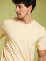 Remera de manga corta color arena, con cuello redondo y un bolsillo de parche en el pecho.