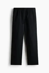 Pantalón negro de corte relajado, confeccionado en mezcla de lino y viscosa, con cintura elástica con cordón de ajuste y bolsillos laterales.