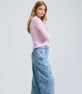 Pantalón de jean estilo baggy con cintura media, corte recto y holgado. Presenta un lavado con efecto dirty y detalles de bordados deshilachados verticales en la parte frontal de las piernas. Cuenta con cierre frontal con botón y cremallera, presillas en la cintura y bolsillos funcionales.