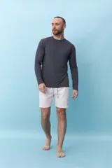 Short de baño de corte recto con estampado de rayas verticales finas en color verde claro. Cuenta con cintura elástica ajustable mediante cordón y bolsillos laterales.