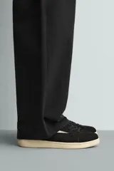 Zapatilla de estilo retro con cordones, confeccionada en una combinación de piezas de gamuza y material sintético. Presenta suela de goma a contraste y diseño de paneles laterales.