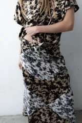 Falda larga y recta con diseño en bloques geométricos que combinan estampado floral abstracto en tonos beige, blanco y negro.