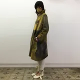 Tapado largo de lana merino afieltrada color gris con toques de amarillo. Diseño abierto al frente, de corte amplio y mangas largas.