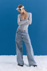 Jean de corte oversize y tiro medio-alto, en color celeste con lavado tipo ice y acabado con foil transparente. Presenta un diseño de pierna ancha y estampa en la parte trasera.