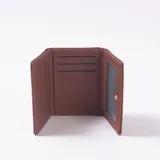 Billetera Iveria color marrón chocolate, de diseño rectangular con solapa frontal y detalle de aplique metálico plateado en el contorno del cierre.